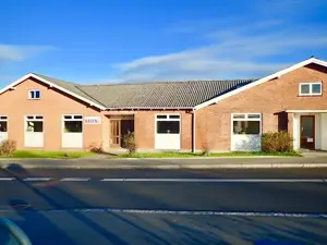 Basen Nord i Birkerød. En rød hesteskoformet bygning i røde mursten.