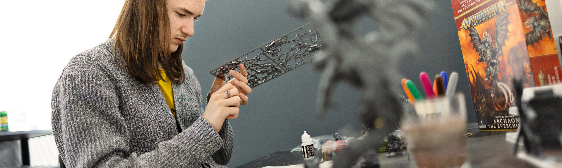 Ungt menneske der sidder og samler en dragefigur