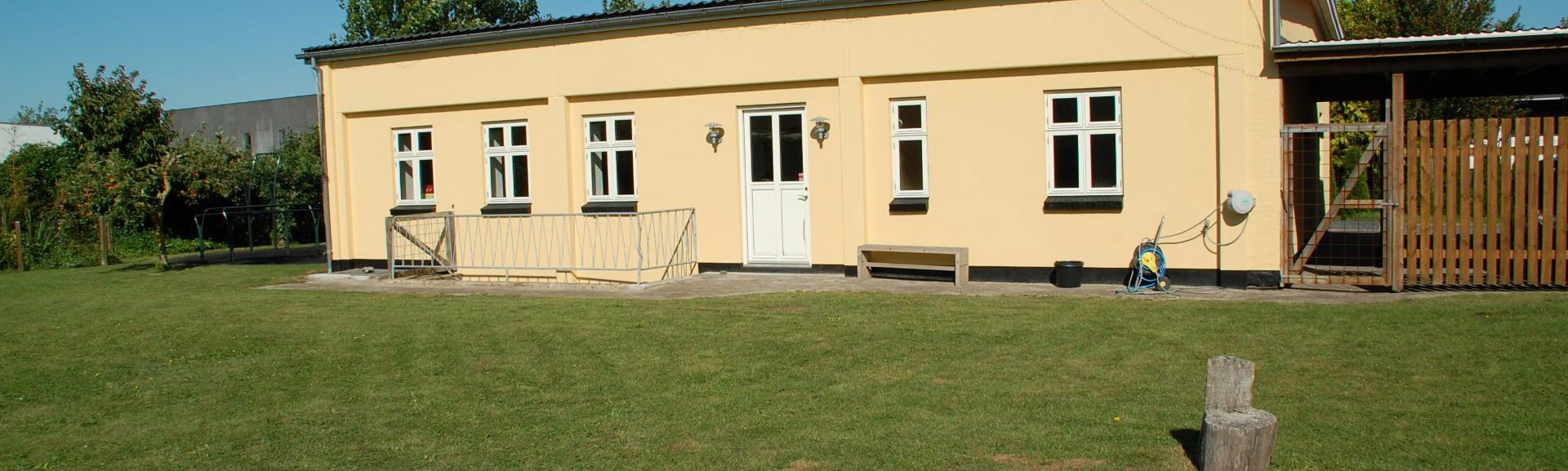 Gul huslænge og grøn græsplæne - en del af Basens afd. på Fyn