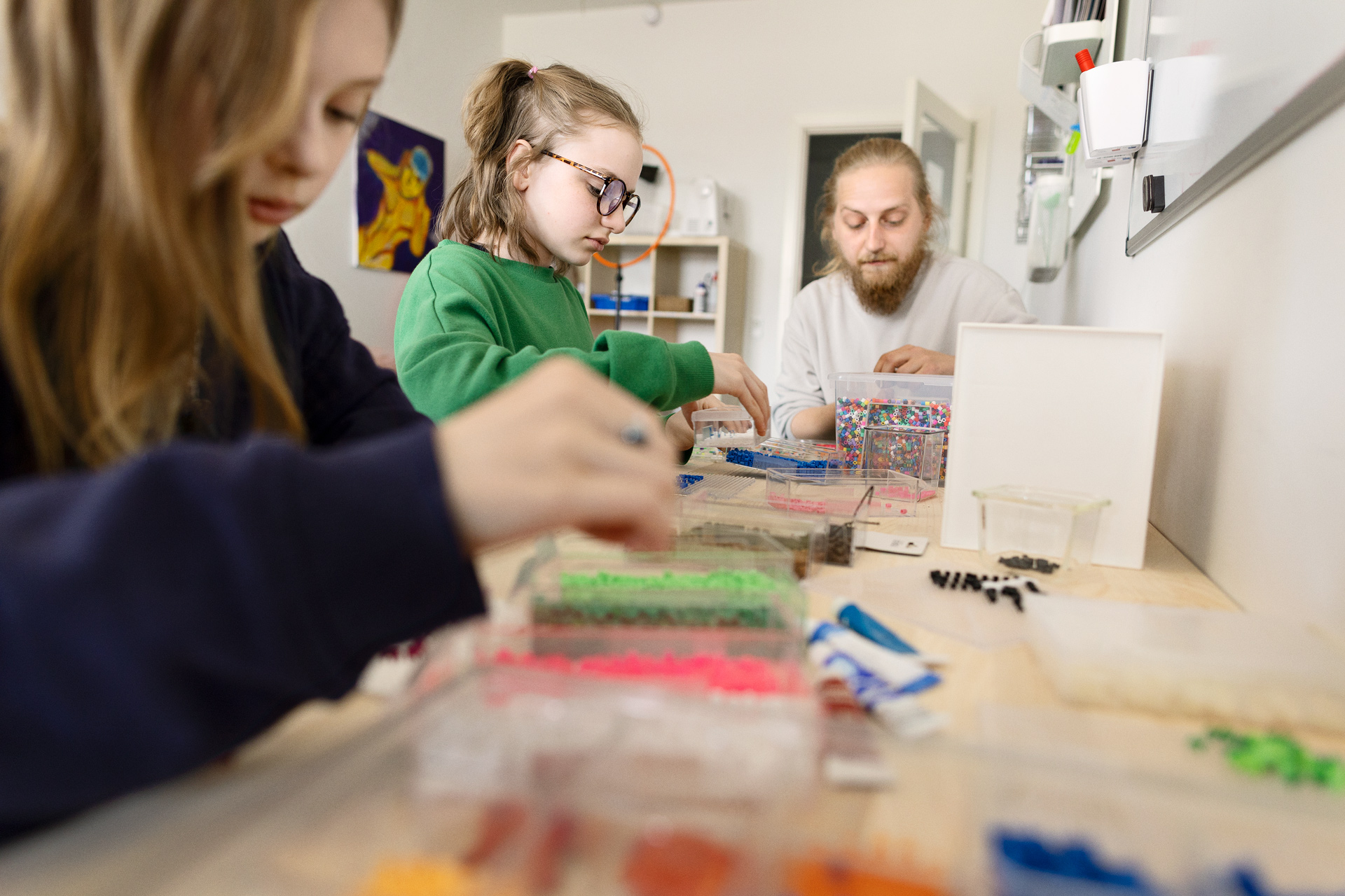 To elever der laver perleplader og en underviser