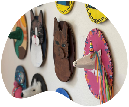 Små dyrefigurer i profil der hænger på en væg 