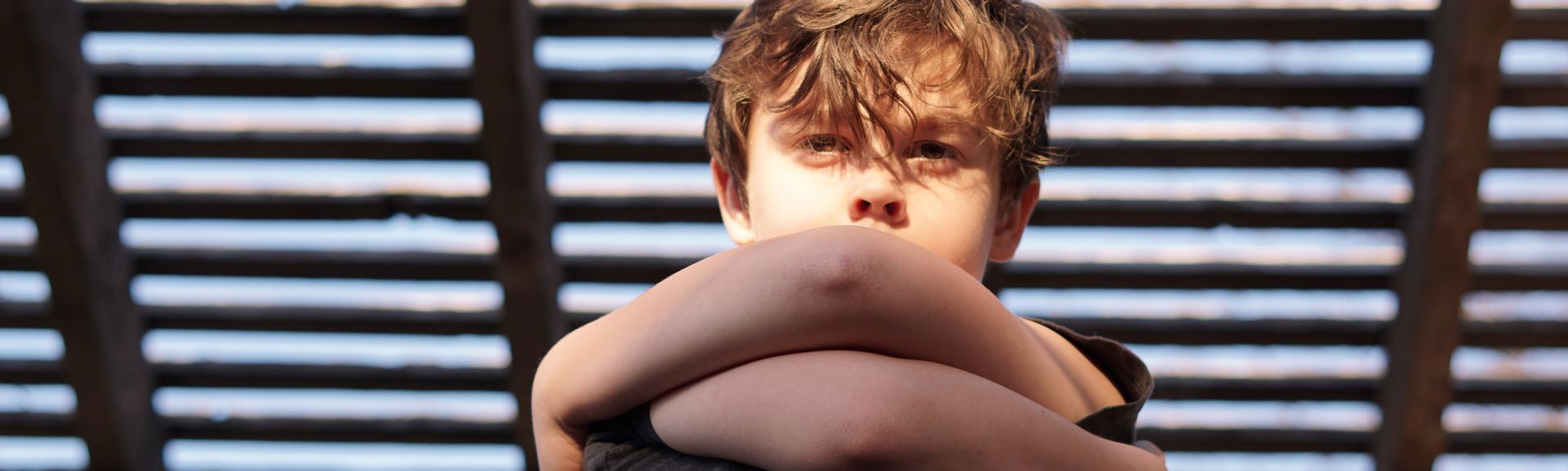 Dreng med armene samlet foran kroppen