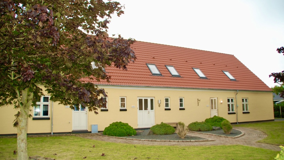 Billede af Basen Fyn på Thulevej i Odense. En gul bygning med rødt tegltag omgivet af en græsplæne og et grønt tag.