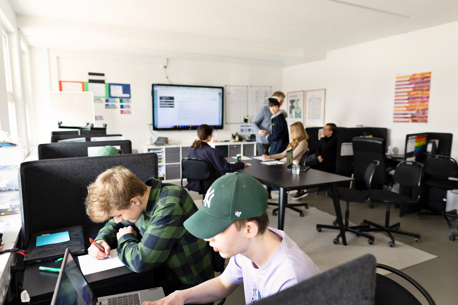 To elever, der koncentrerer sig i et klasselokale. 